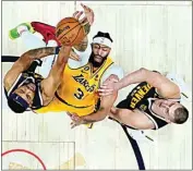  ?? JACK DEMPSEY / AP ?? Los Angeles Lakers forward Anthony Davis (3) shoots as Denver Nuggets center Nikola Jokic, right, and Denver Nuggets forward Bruce Brown defend during the second half on Thursday in Denver.