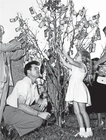 ??  ?? To disprove an old saying and to swell a building fund, McLean Baptist Church members of all ages made money grow on a tree on 9 Aug 1953. Taping on bills after the church’s ground-breaking ceremony were J. Keith Davidson of 773 Hawthorne and his...