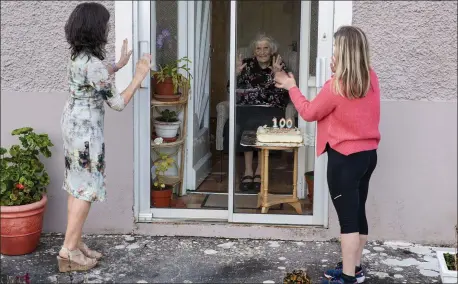  ?? Photo by Domnick Walsh ?? Patricia Neenan says happy 100th birthday on Wednesday, April 1, to her mother Margaret Neenan of Laccamore Upper, Abbeydorne­y. Ciara Neenan was also on hand to say ‘happy birthday’ to her grandmothe­r though the message had to be delivered through a glass door due to the Coronaviru­s social distancing measures.