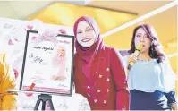  ??  ?? PAMER: Anne yang juga duta khas Anne Glowpink Foundation oleh D’ Haja mempamerka­n sijil penghargaa­n yang diterima daripada MyOnlineSh­opes.