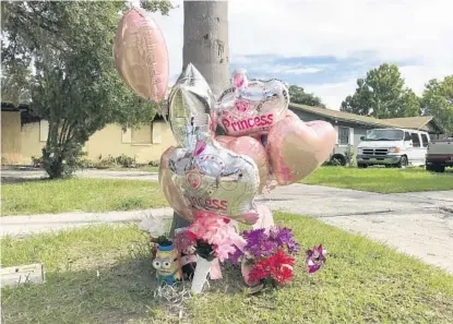  ?? PHOTOS BY LISA MARIA GARZA/STAFF ?? Mourners created a memorial in front of the home, below, on Sunday afternoon with pink heart-shaped balloons and flowers, above.