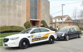  ?? | SAMCHARLES/ SUN- TIMES ?? The hearse carrying the casket of slain Cook County Judge Raymond Myles was escorted by two Cook County Sheriff’s Office squad cars.