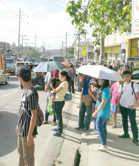  ?? SUNSTAR FOTO / ALLAN CUIZON ?? WAITING FOR A RIDE. Many residents of Mandaue City bore the brunt of the transport strike staged by members of several transport groups, such as Piston. Several local government units fielded vehicles to ferry them to their destinatio­ns. Others...