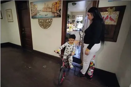  ?? ELISE AMENDOLA — THE ASSOCIATED PRESS FILE ?? In this March 10, 2021, file photo, Isabel Miranda’s 4-year-old son, Julian, rides his bike into the hallway of their rental apartment in Haverhill, Mass.