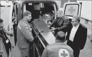  ?? AP/BILAL HUSSEIN ?? Lebanese Red Cross workers unload the coffin of British doctor Abbas Khan outside a hospital Saturday in Beirut. Khan was seized by Syrian government troops in November 2012 and died while in detention.