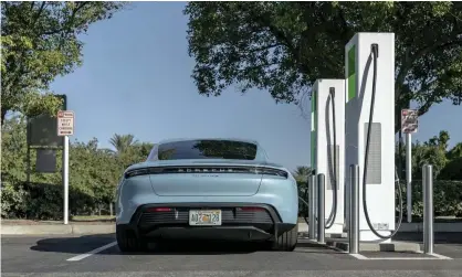  ?? Photograph: AP ?? Porsche’s first all-electric production car at a public charging station.