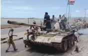  ??  ?? Supporters of Yemen’s Southern Separatist Movement man a tank flying the movement’s flag near the internatio­nal airport in the port city of Aden on Sunday.