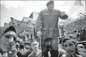  ?? AP/ARIANA CUBILLOS ?? A cutout of Venezuela’s late President Hugo Chavez stands among supporters during a rally backing the the new constituti­onal assembly outside the National Assembly building in Caracas, Venezuela, on Monday.