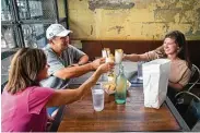  ?? Mark Mulligan / Staff photograph­er ?? Barb and John Barajas toast with their daughter Kelsey on Friday at Eight Row Flint in Houston.