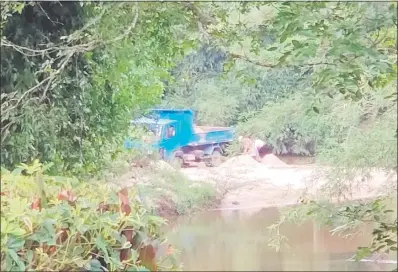  ??  ?? Momento en que dos personas cargan la arena extraída del río en un vehículo, cuyo propietari­o se desconoce. Esta práctica se observa todos los días, según los pobladores.