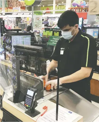  ?? JONATHAN HAYWARD / THE CANADIAN PRESS FILES ?? Across Canada, Plexiglas barriers have been erected to protect the cashiers at a grocery stores.
Even so, hundreds of workers have been affected by COVID-19 and several have died.