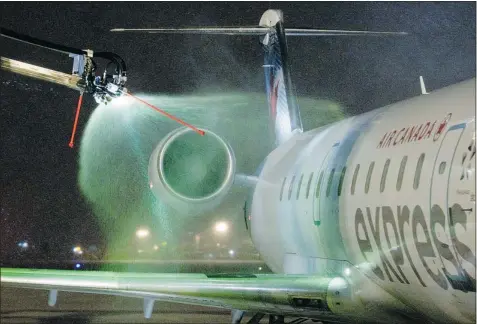  ?? PHIL CARPENTER/ THE GAZETTE ?? Cold weather treatment: As snow fell last Saturday, an Air Canada Bombardier CRJ received Type 4 anti-icing fluid at the de-icing facility at Pierre Elliott Trudeau Internatio­nal Airport. De-icing melts and washes off snow, ice or frost. The strength...