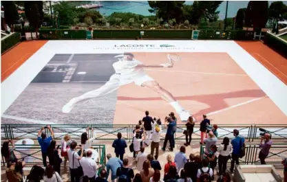  ??  ?? The much-bigger-than-life image of Djokovic on two clay courts is unveiled before the guests.