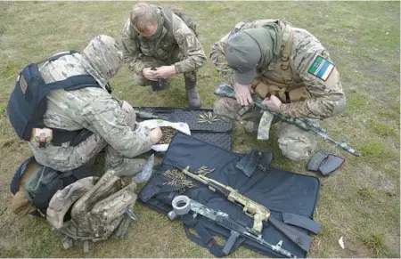  ?? ANDREW KRAVCHENKO/AP ?? Volunteer soldiers attend a military training session Saturday at a camp outside Kyiv, Ukraine.