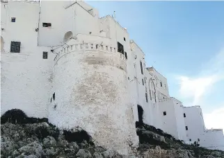  ??  ?? The whitewashe­d walled city of Ostuni is perched on a hill above olive groves.