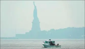  ?? TIMOTHY A. CLARY / AFP ?? A hazy Statue of Liberty is seen from New Jersey on Tuesday. New York officials issued an air quality health advisory due to the West Coast wildfires.