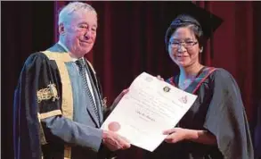  ?? PIC BY DANIAL SAAD ?? National University of Ireland Chancellor Dr Maurice Manning (left) presenting Dr Esther Hor Shan Lin her medical degree in George Town on Sunday.