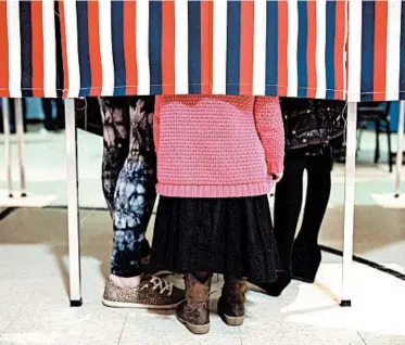  ?? TAMIR KALIFA/THE NEW YORK TIMES ?? Meagan Isabelle brought her children with her to vote Tuesday at a church polling place in Merrimack, New Hampshire.