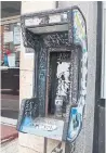  ??  ?? Graffiti-plastered shells of pay phones are a blight on the streetscap­e on Queen Street West, including this one.