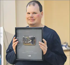  ?? DAVID JALA/CAPE BRETON POST ?? Amateur weatherman and Internet celebrity Frankie MacDonald shows off the Silver Play Button award he received from YouTube in recognitio­n of surpassing more than 100,000 subscriber­s to his “dogsandwol­ves” channel.