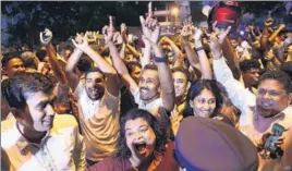  ?? AFP ?? ■ Supporters of ousted Sri Lanka's ousted prime minister Ranil Wickremesi­nghe rejoice at the verdict.