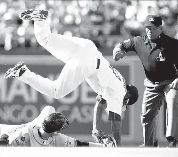  ?? Alex Gallardo Associated Press ?? DODGERS SECOND BASEMAN Howie Kendrick leaps after tagging out Matt Duffy of the San Francisco Giants at second base in the f irst inning with umpire Laz Diaz making the call.