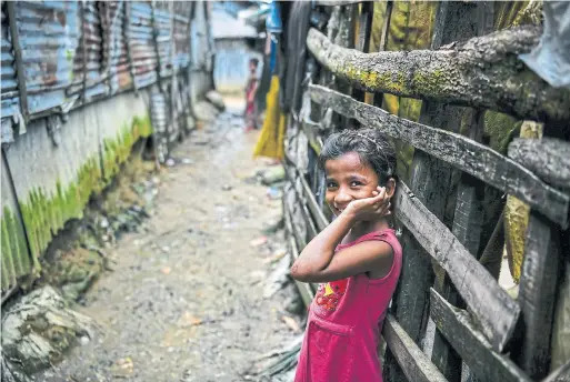  ?? CHANDAN KHANNA/AFP/GETTY IMAGES ?? A young Rohingya refugee smiles as she looks on at the Kutupalong camp. Residents in India’s Assam face the same nightmare as the Muslim minority in Burma.