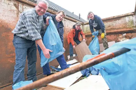  ?? FOTO: ULLA MICHELS ?? Ab in den Container: Uwe Schollenbe­rg, Klaus Petrausch, Axel Ajnenkel und Uwe Mauermann beim Sammeln am Toeppersee.