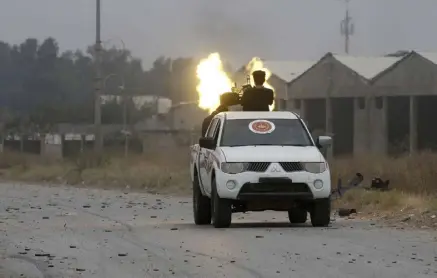  ??  ?? مقاتل موالٍ لحكومة الوفاق الوطني الليبية المعترف بها دوليا يطلق النار في اتجاه القوات الموالية لحفتر المدعوم عسكريا من الإمارات