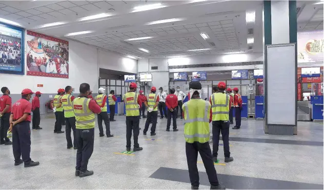  ?? Agence France-presse ?? ↑
Airport staff of Spice Jet take a briefing from a senior (centre) at the Sardar Vallabhbha­i Patel Internatio­nal Airport in Ahmedabad on Sunday.