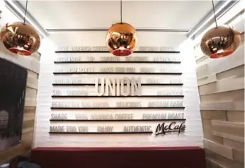  ?? RICHARD LAUTENS PHOTOS/TORONTO STAR ?? Canada’s first stand-alone McCafé has a modern look with copper lamp shades and wood finishes to attract commuters who pass through Union Station. The café is located in the station’s newly built York concourse area.