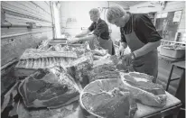  ?? REUTERS ?? Butchers Allan and Gerald vande Bruinhorst work on a beef carcass as part of their uncle’s business in Picture Butte, Alta.