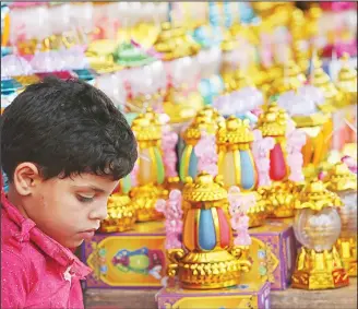  ??  ?? A Palestinia­n boy shops for a traditiona­l lantern for the Holy Month of Ramadan, at the main market in Gaza City, on May 16. Muslims throughout the world are preparing to celebrate Ramadan, the holiest month in the Islamic
calendar, refraining from...