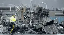  ?? JONATHAN HAYWARD/THE CANADIAN PRESS ?? A police officer is seen taking pictures at the scene of a train collision at the Canadian Pacific rail yard in Port Coquitlam, B.C., on Tuesday.