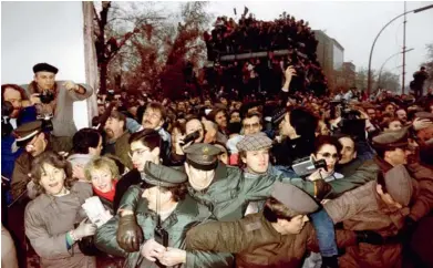  ?? PATRICK HERTZOG/ AFP ?? A las 7 p. m. del 9 de noviembre de 1989, la policía de Alemania Oriental y Occidental contiene la multitud de berlineses quieren atravesar el muro en la plaza Potsdamer.