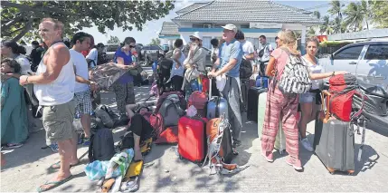  ?? AFP ?? Foreign tourists wait for transporta­tion after arriving from the nearby Gili islands at the port in Bangsal, northern Lombok island yesterday, a day after a 6.9 magnitude earthquake struck the area. According to a Reuters report, Indonesia’s efforts to...