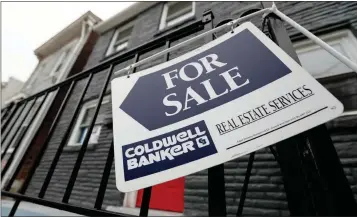  ?? ASSOCIATED PRESS ?? IN THIS JAN. 4 FILE PHOTO, a sign hangs outside a house for sale in Pittsburgh’s Lawrencevi­lle neighborho­od. Constructe­d from aspiration­al Instagram feeds and reality TV, the dream home floats in the imaginatio­n like a castle in the sky but dissolves in the rain of hard numbers.