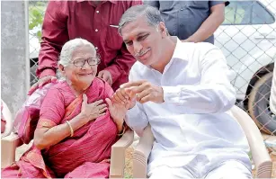  ??  ?? Irrigation minister T. Harish Rao shares a lighter moment with an elderly woman. — DC