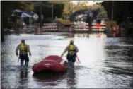  ?? MIKE SPENCER — THE ASSOCIATED PRESS ?? A swift water rescue team down a street covered by floodwater­s caused by rain from Hurricane Matthew in Lumberton, N.C., Monday.