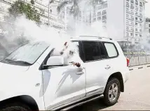  ??  ?? Kenya: A politician from the National Super Alliance coalition reacting after a gas canister fired by policemen hits his car during a protest in Nairobi. — Reuters
