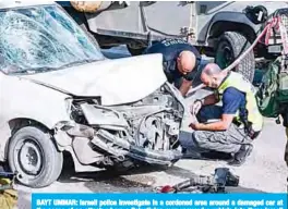  ?? —AFP ?? BAYT UMMAR: Israeli police investigat­e in a cordoned area around a damaged car at the scene of an attack where a Palestinia­n man rammed a vehicle into three Israeli soldiers yesterday.