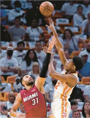  ?? WILFREDO LEE/AP ?? Atlanta forward De’Andre Hunter, a former University of Virginia star, puts up a shot against Miami guard Max Strus during Tuesday night’s playoff game. Hunter finished with a game-high 35 points.