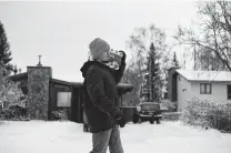  ?? Joshua Corbett / New York Times ?? An Anchorage resident carries water home from a store after a precaution­ary boil-water advisory went out following Friday’s quake. There were no reports of deaths or serious injuries.