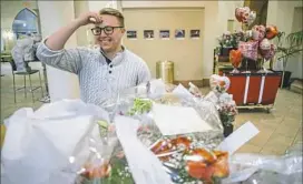  ?? Andrew Rush/Post-Gazette ?? Parker Werns, a graduate assistant for the Honors Program at Point Park University, sorts Valentine’s Day flowers for delivery Wednesday. Students in the program delivered the flowers to raise money for travel.