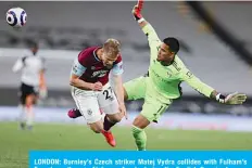  ?? —AFP ?? LONDON: Burnley’s Czech striker Matej Vydra collides with Fulham’s French goalkeeper Alphonse Areola during the English Premier League football match at Craven Cottage on Monday.