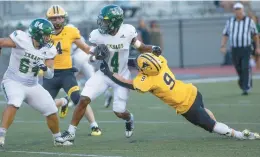  ?? DOUGLAS KILPATRICK/SPECIAL TO THE MORNING CALL ?? Emmaus running back Tylik Jarvis, 4, gets taken down by Freedom’s Sampson Neufler, 9, in the first half of Friday’s season opener at the Bethlehem Area School District Stadium at Liberty High School.