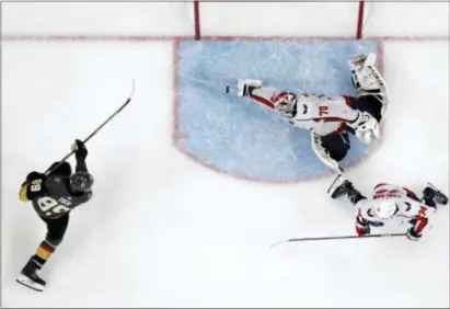  ?? JOHN LOCHER — THE ASSOCIATED PRESS ?? Washington goaltender Braden Holtby, center, makes a stick save on a shot by Vegas’ Alex Tuch, left, as John Carlson watches during the third period in Game 2 of the Stanley Cup Final on Wednesday in Las Vegas.