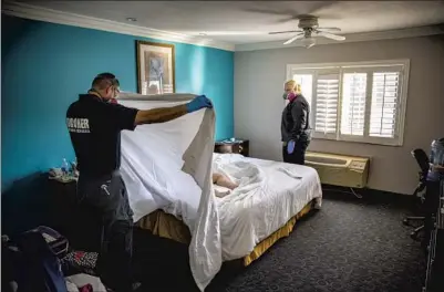  ?? KRISTINA McGUIRE Jay L. Clendenin Los Angeles Times ?? and Jerry Meza of the coroner’s off ice with Judy Bounthong’s body in a West Covina hotel room.