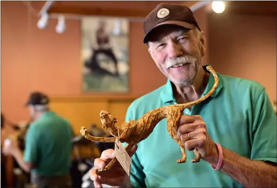  ?? JENNY SPARKS — LOVELAND REPORTER-HERALD ?? Loveland sculptor George Lundeen shows off his autioneeri­ng skills Friday as he holds a bronze piece titled Stretch by artist Karryl Salit at his studio in Loveland. Lundeen will be the auctioneer during the 2023Artist­s’ Charitable Fund Auction where this piece is one of many to be auctioned off.