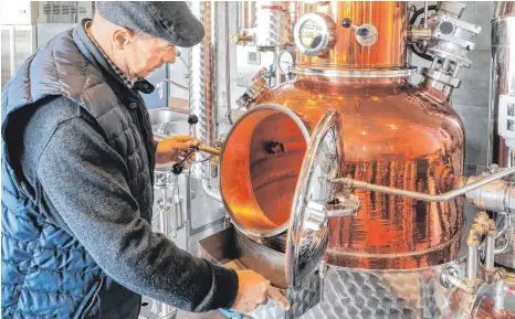  ?? FOTO: ANDY HEINRICH ?? Der Kressbronn­er Brenner Uwe Osswald kontrollie­rt fachmännis­ch die Befüllung seiner Destillati­onsanlage.